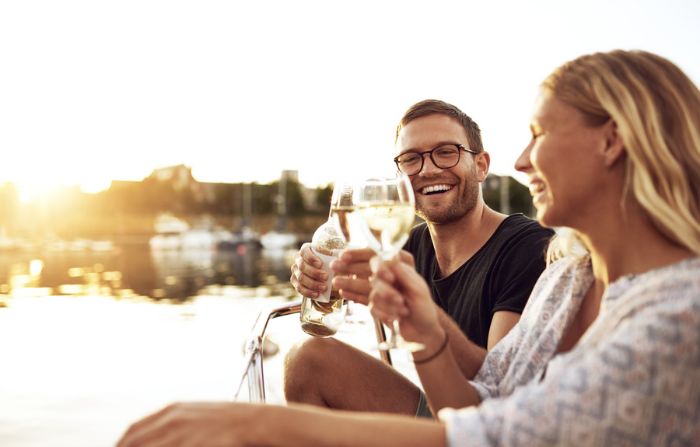 homem e mulher brindando com vinho branco